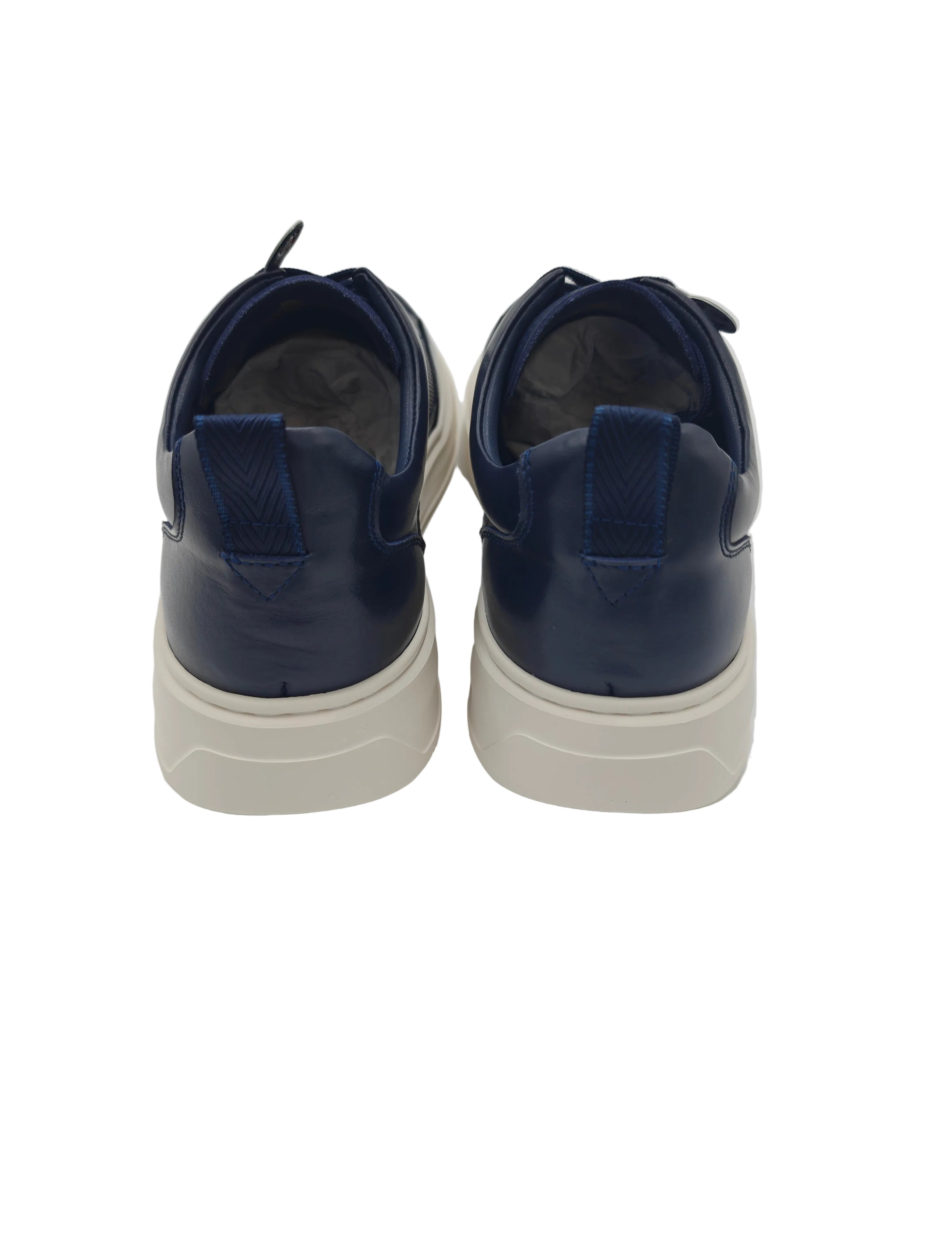 Pair of navy blue sneakers with white soles on a white background