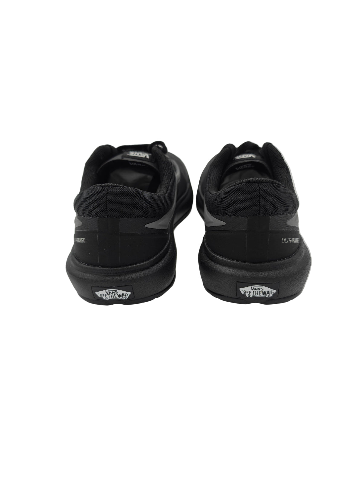Black sneakers with visible brand logo on a light gray surface