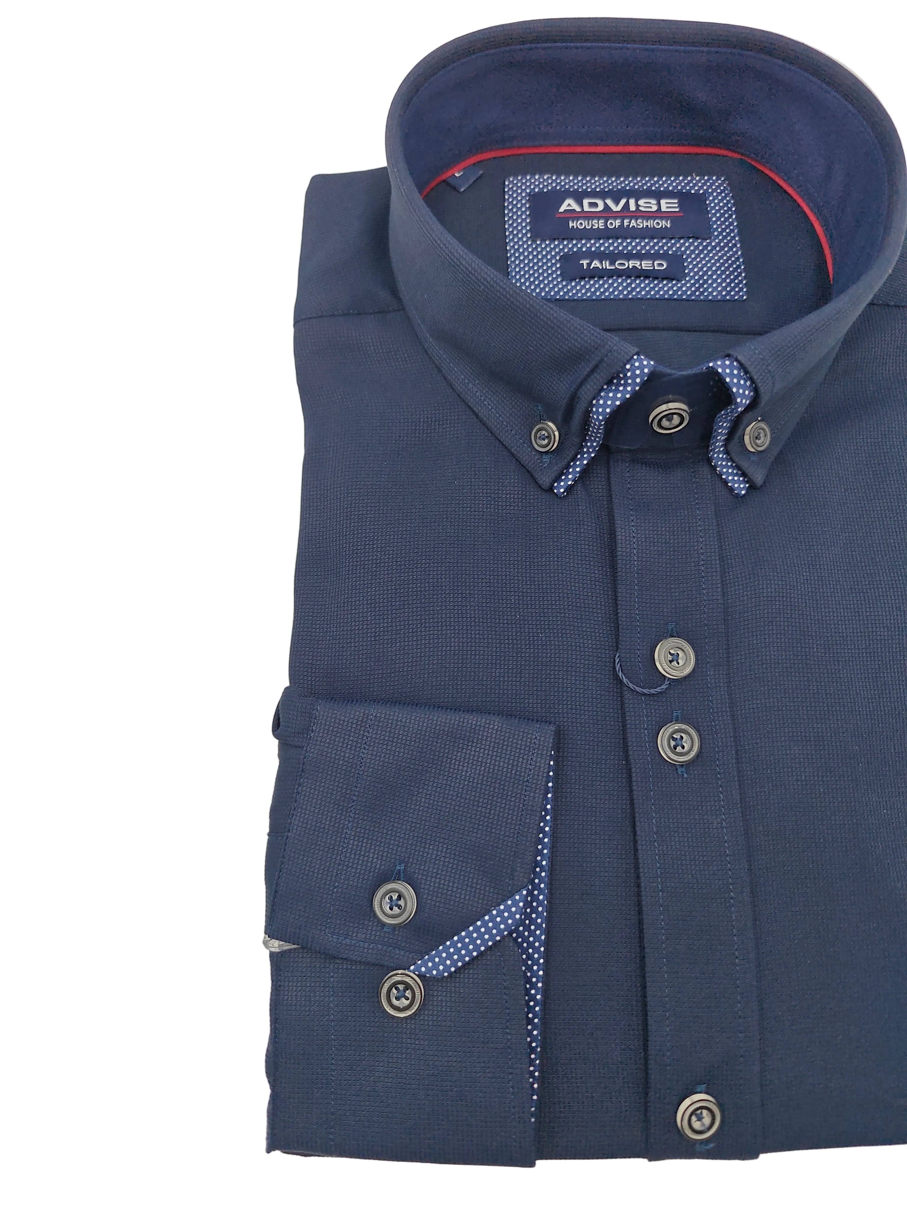 Close up of a folded navy shirt with brand label on a light gray background