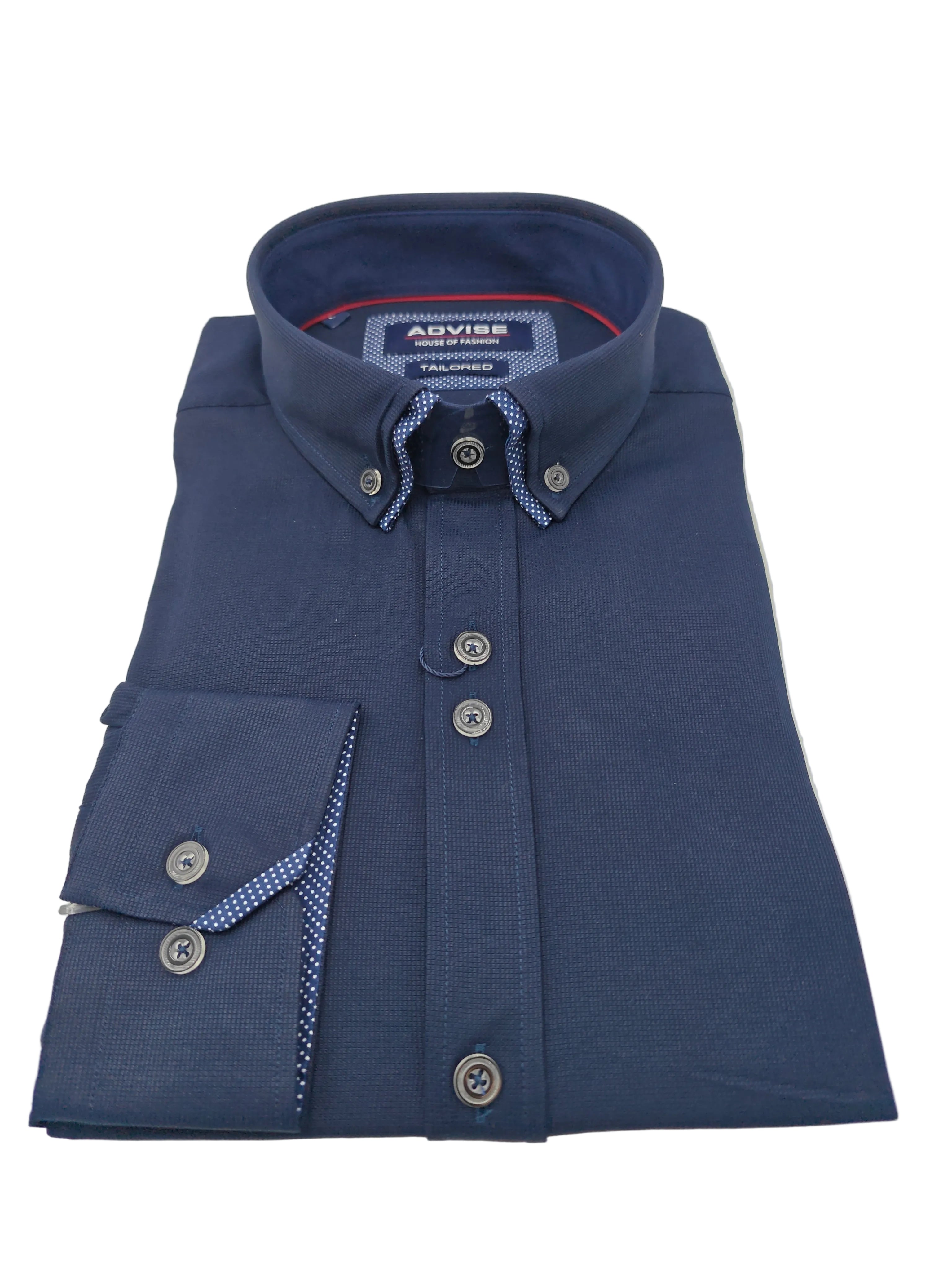 Folded navy shirt with collar and contrasting buttons on a light gray background