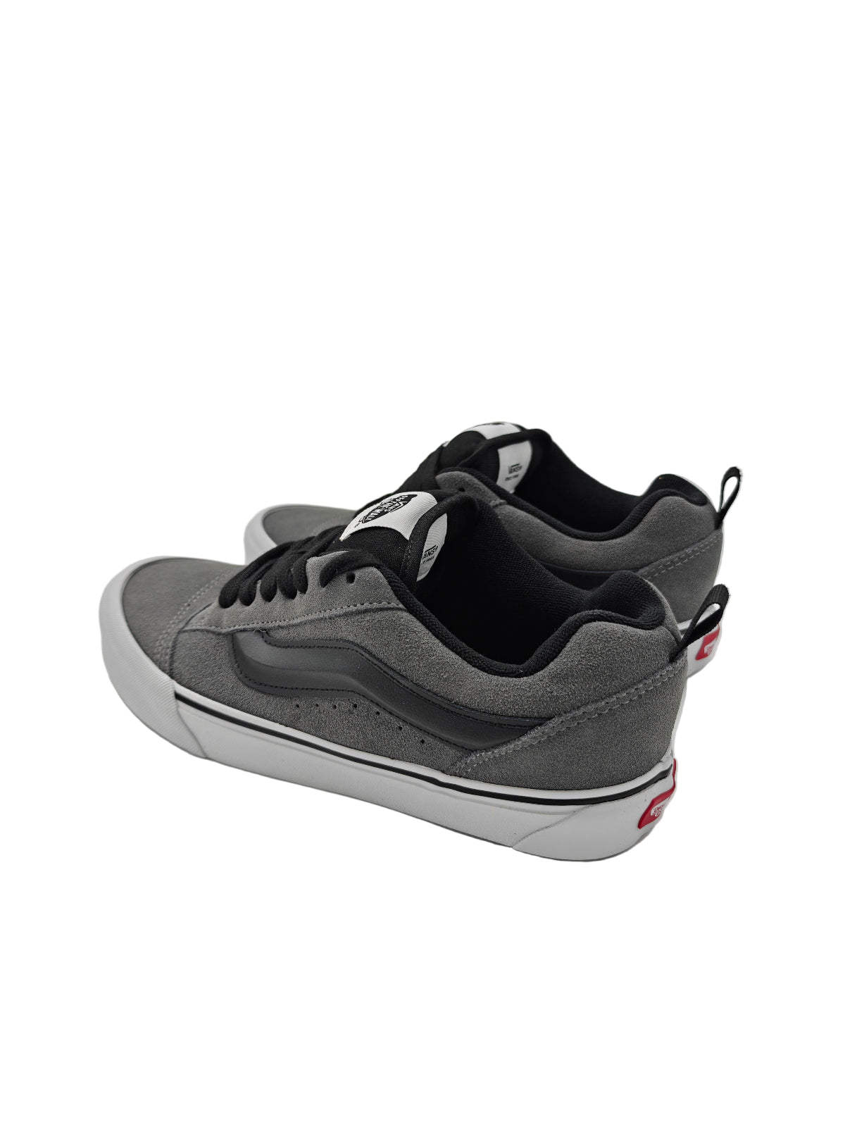 Gray sneakers with black laces on a white surface with a reflective background