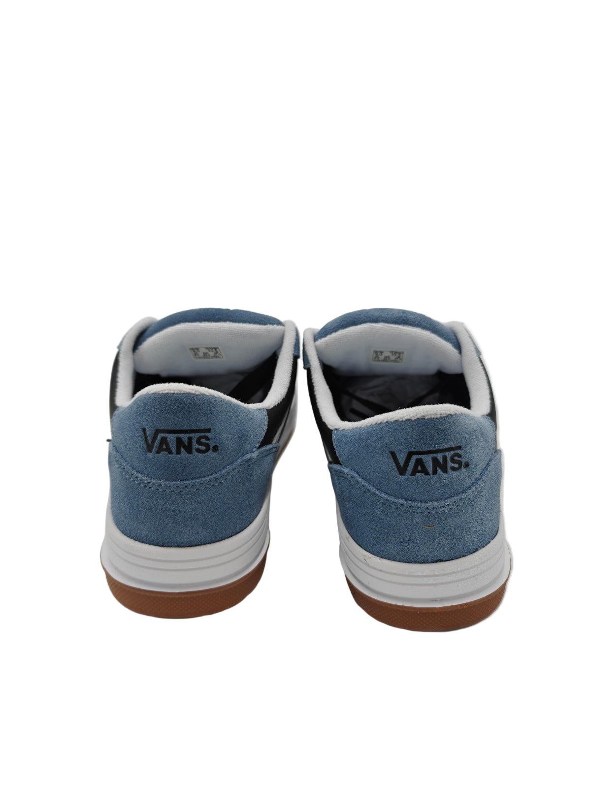 Pair of blue Vans sneakers with white soles on a white surface.