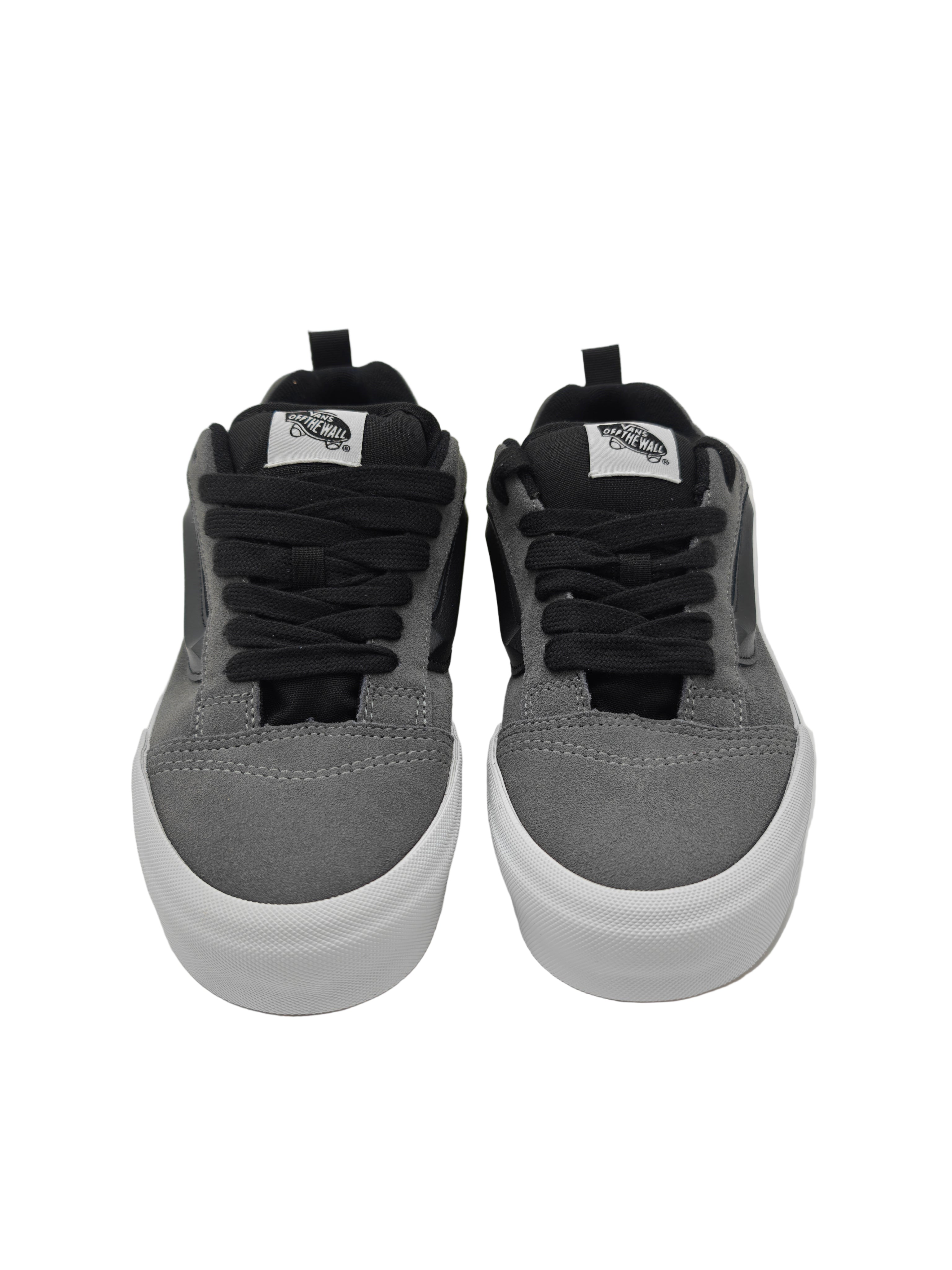 Gray sneakers with black laces and white soles on a light gray background