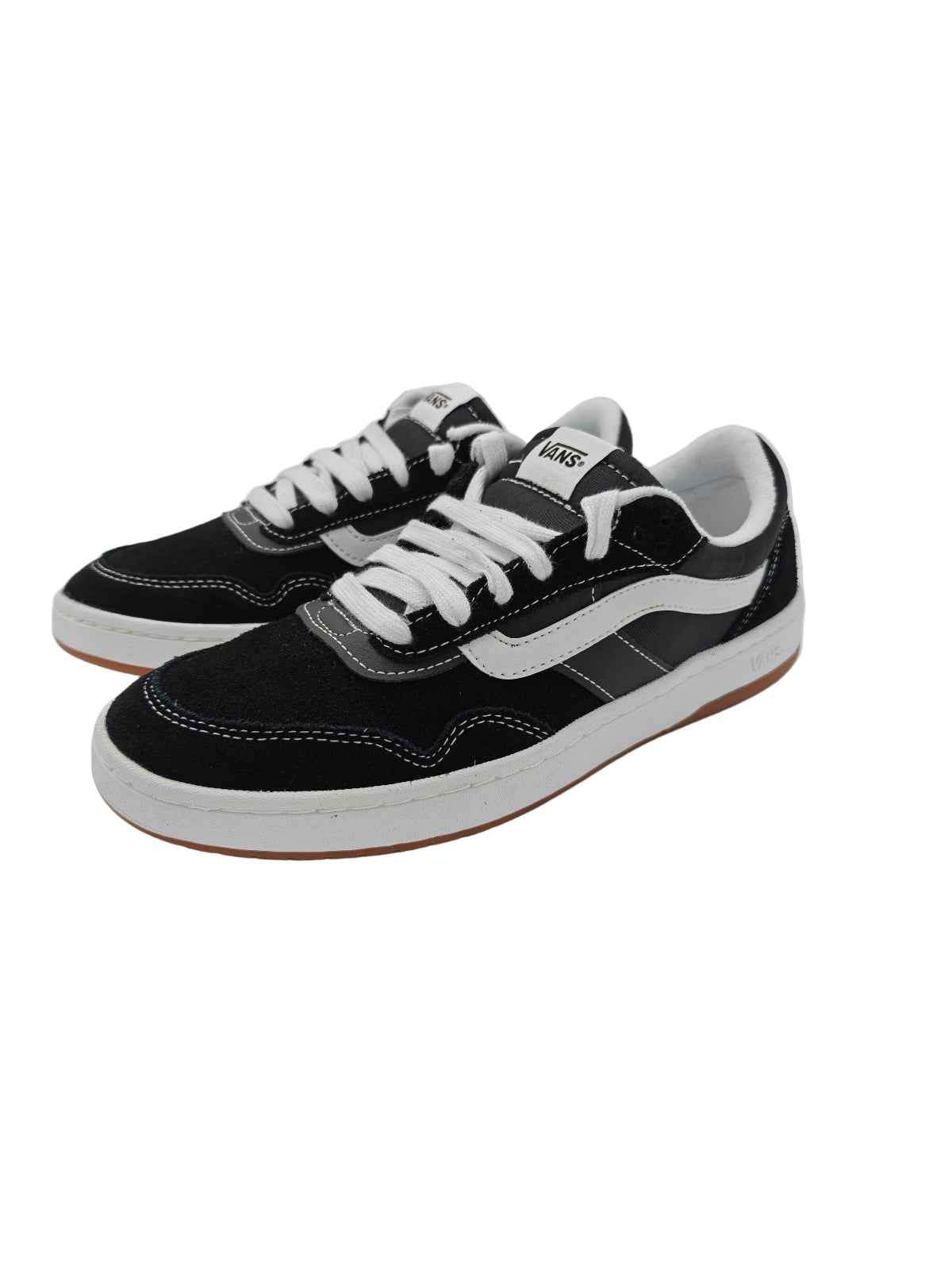 Black and white sneakers on a light gray surface with a reflective background