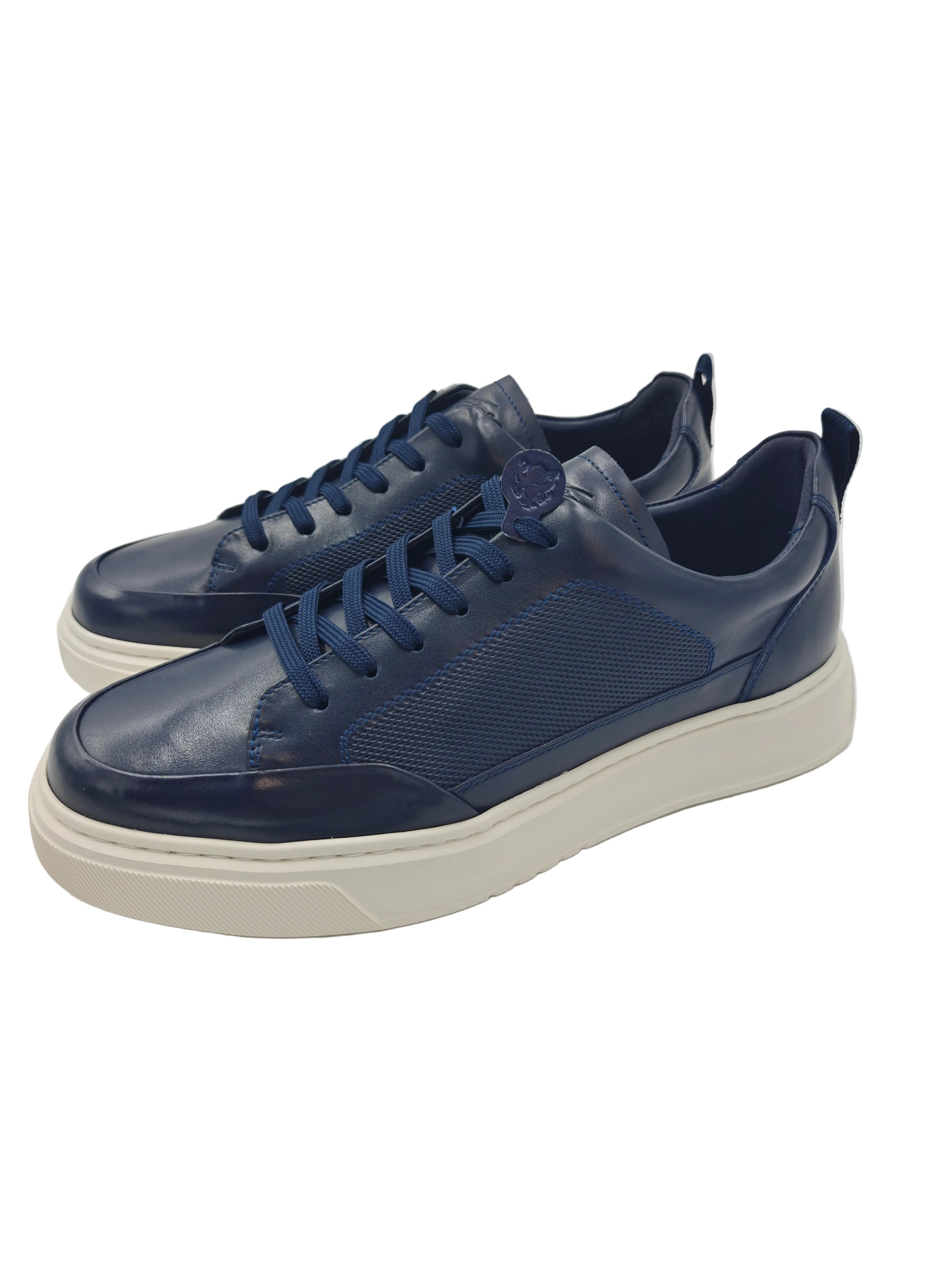 Pair of blue sneakers on a white surface with a reflective background