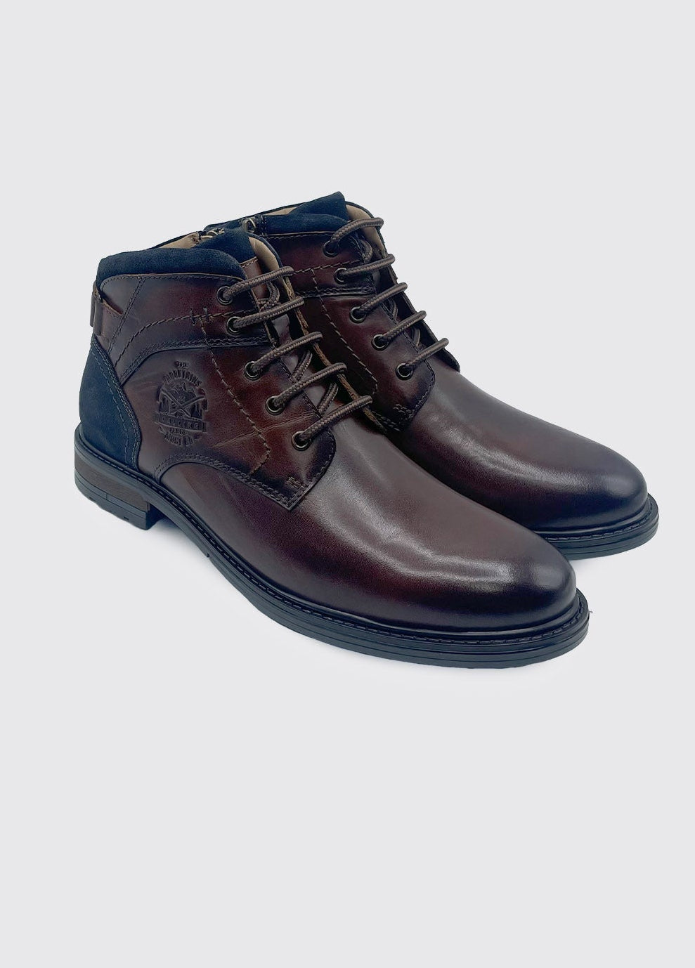 Pair of brown leather boots on a light gray background