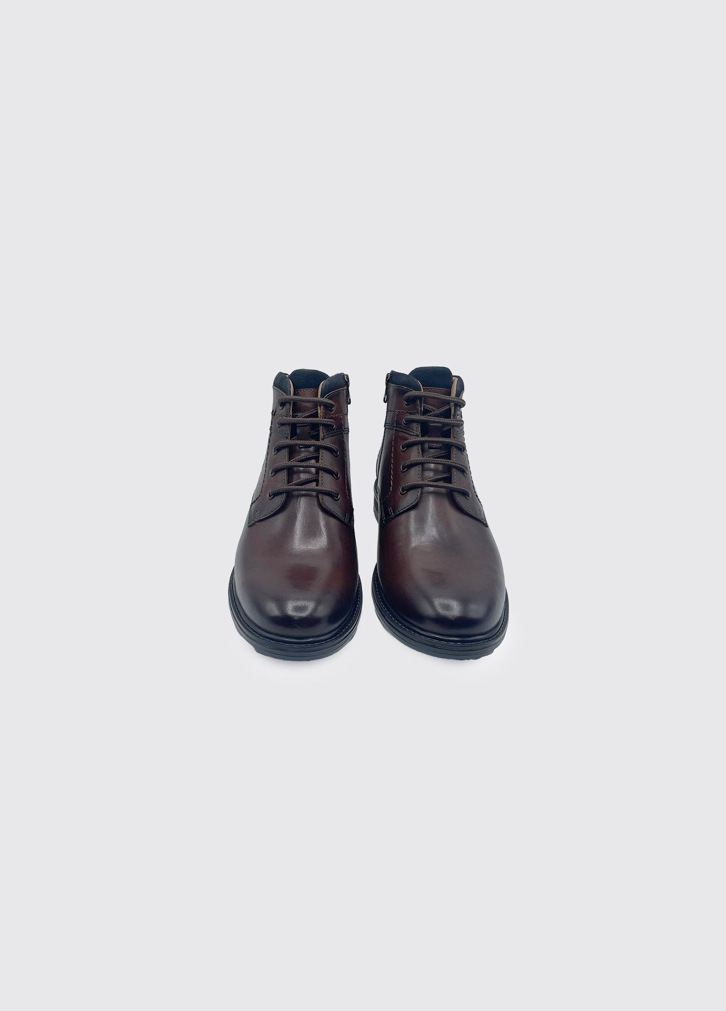 Pair of brown leather boots on a light gray background
