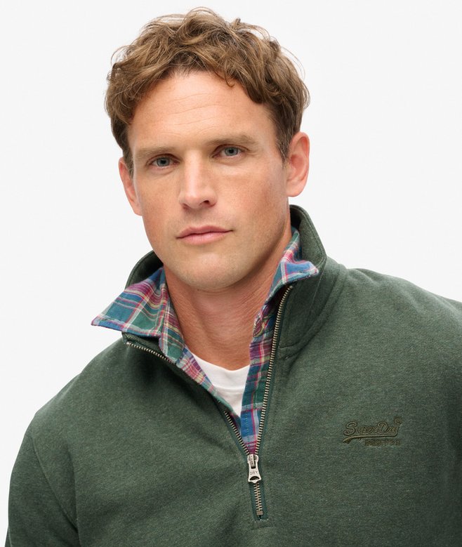 Man wearing a green zip sweat with a visible brand logo on a white background