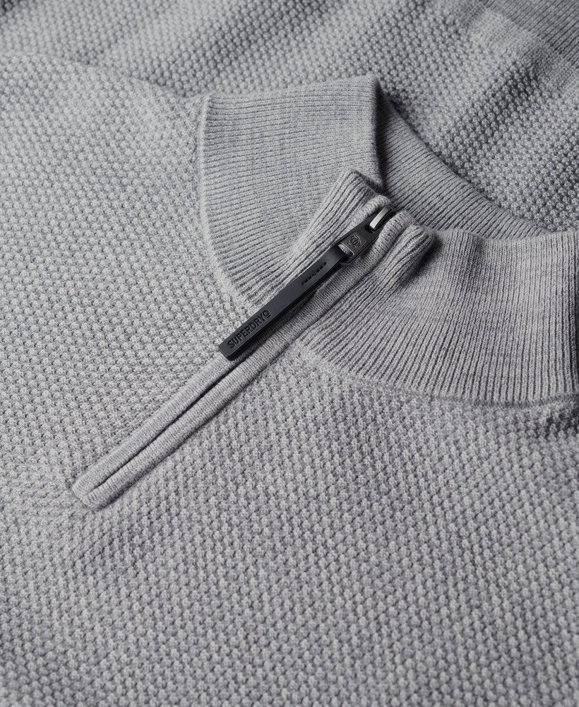 Close-up of a gray knit sweater with a zipper detail.