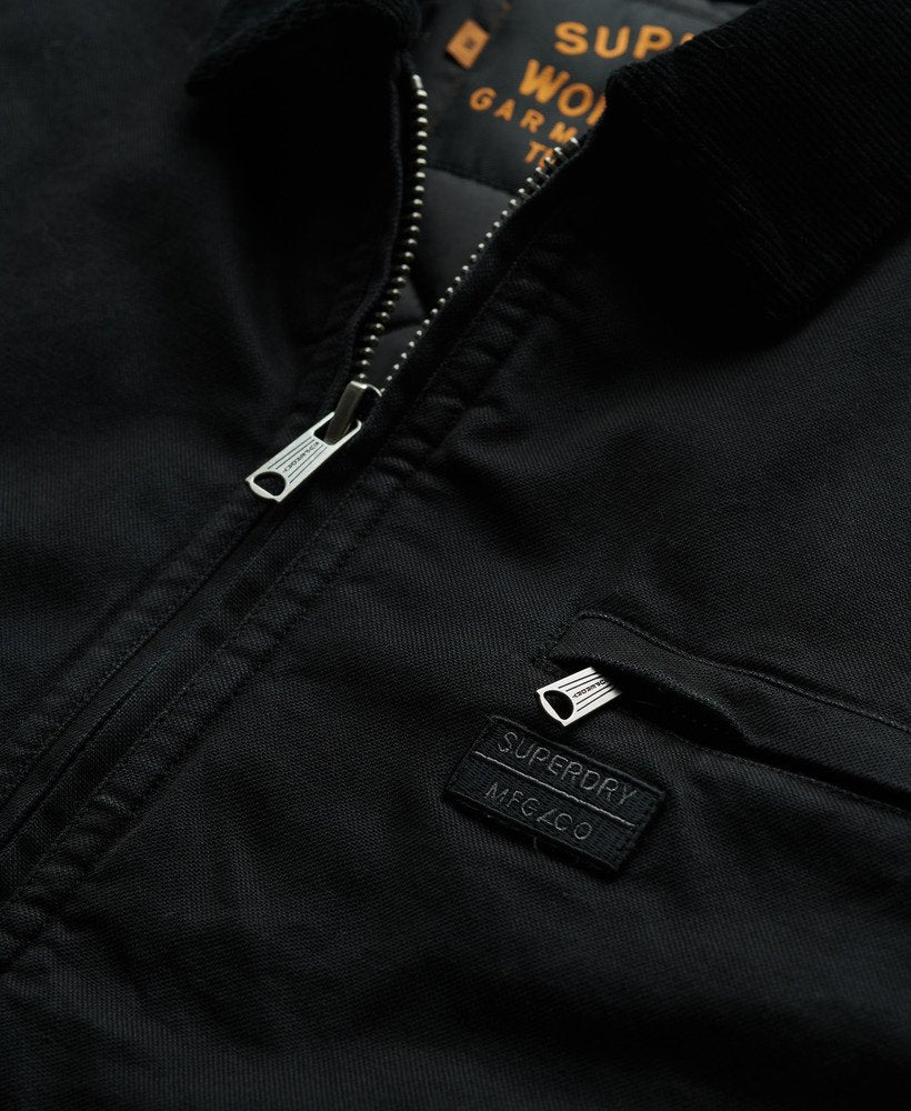 Close-up of a black jacket with a visible brand logo on a dark background