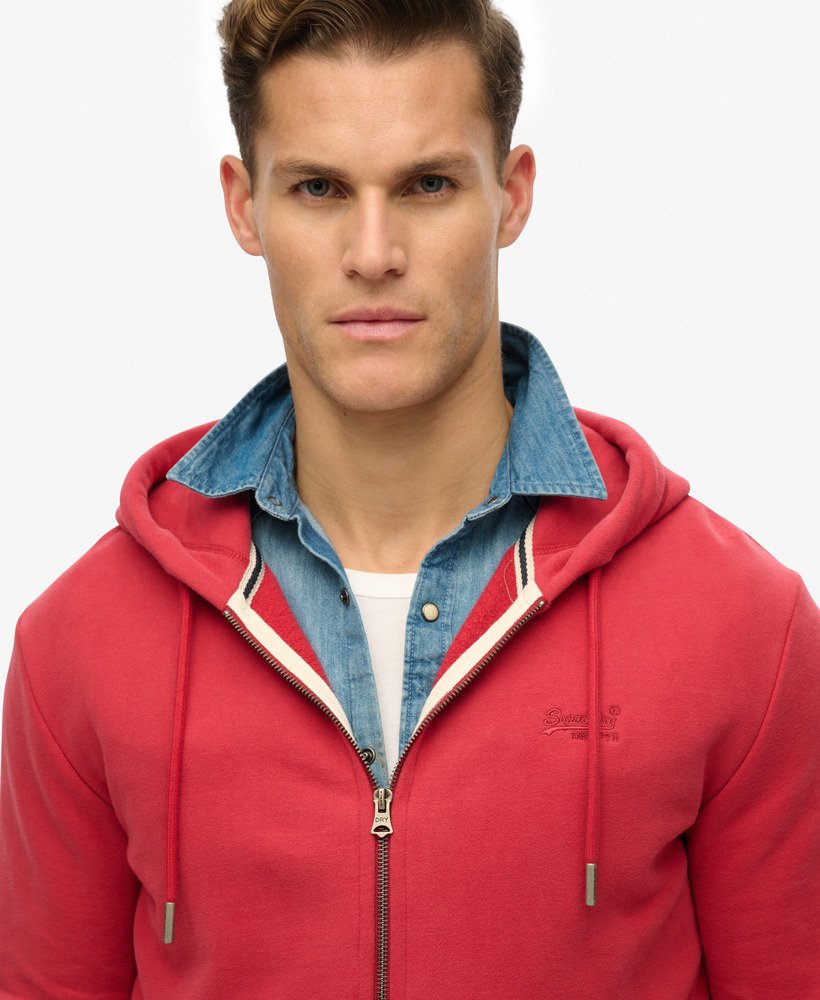 Man wearing a red hoodie with denim collar on a light gray background
