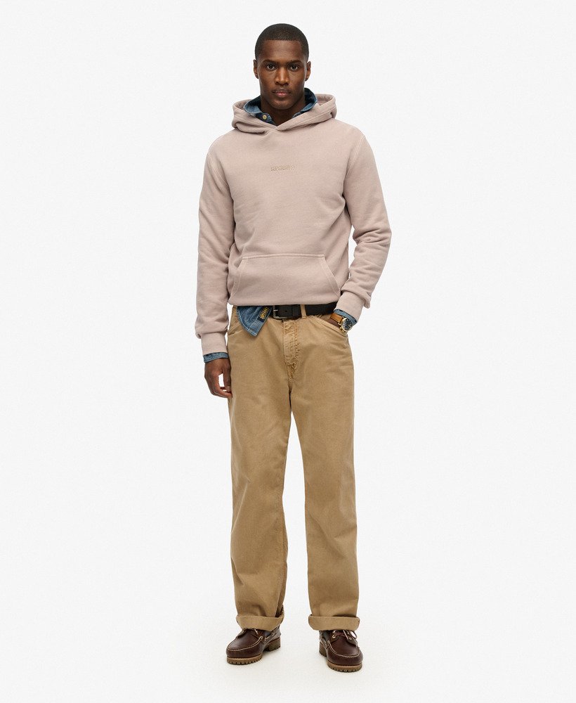 Man wearing a beige hoodie and tan pants on a white background