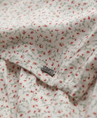Floral patterned fabric with a visible brand label on a white background