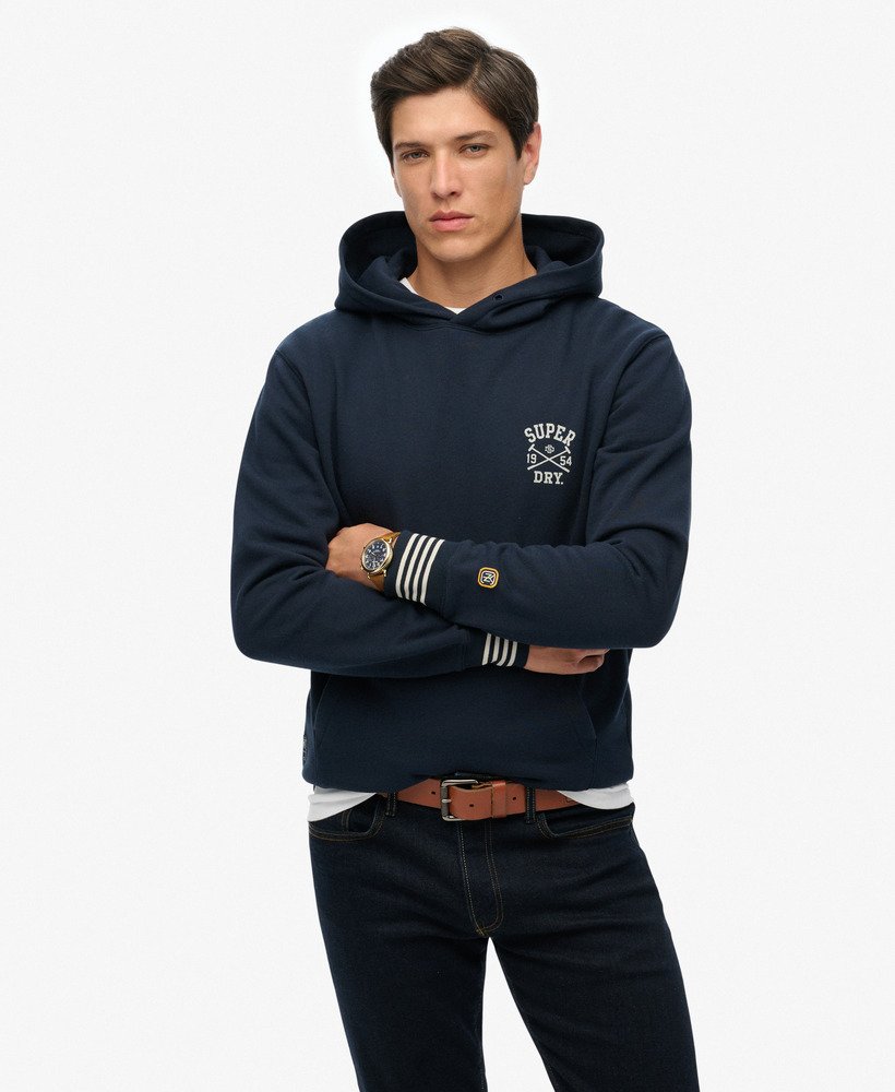 Man wearing a navy hoodie with a brand logo on a white background