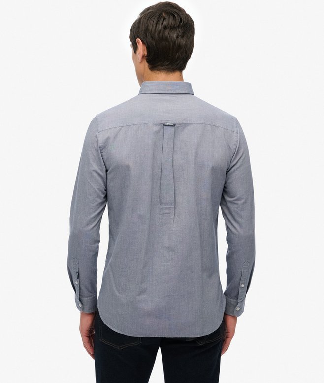 Person wearing a blue button-up shirt on a white background