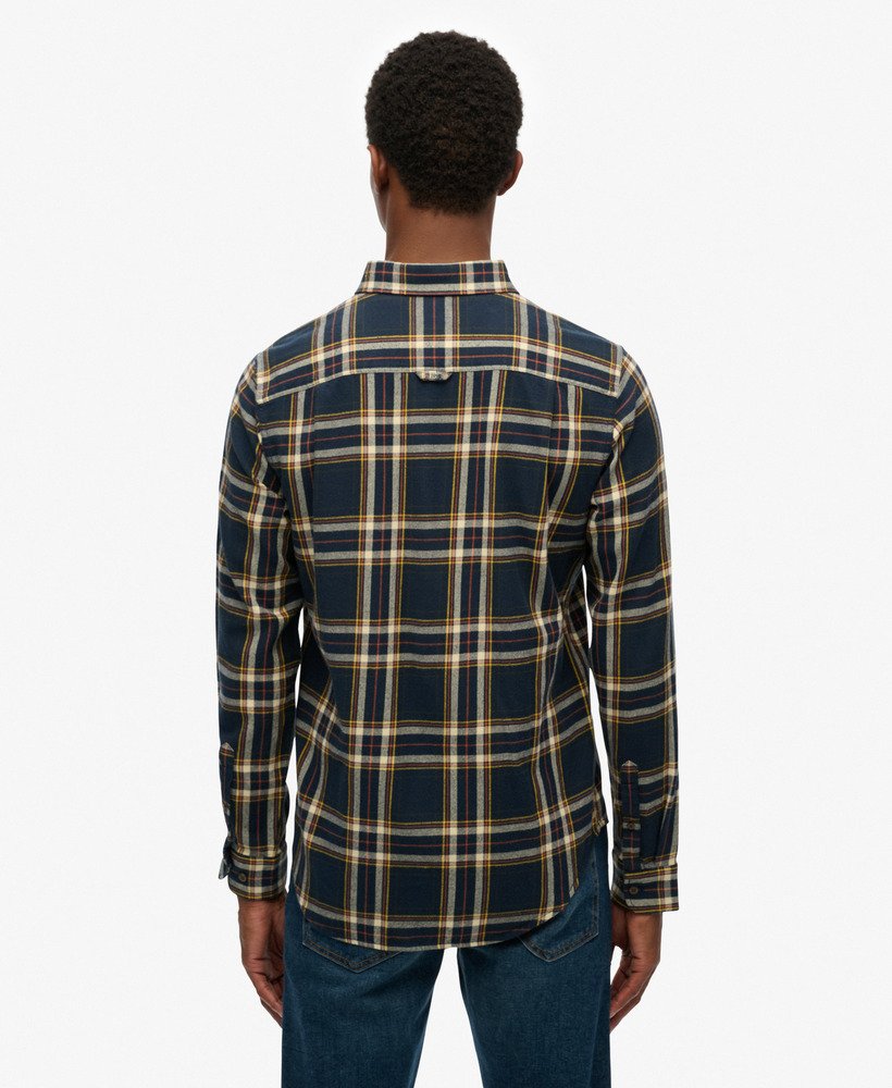Person wearing a blue and yellow plaid shirt on a white background
