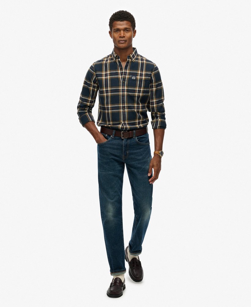 Man wearing a plaid shirt and jeans on a white background