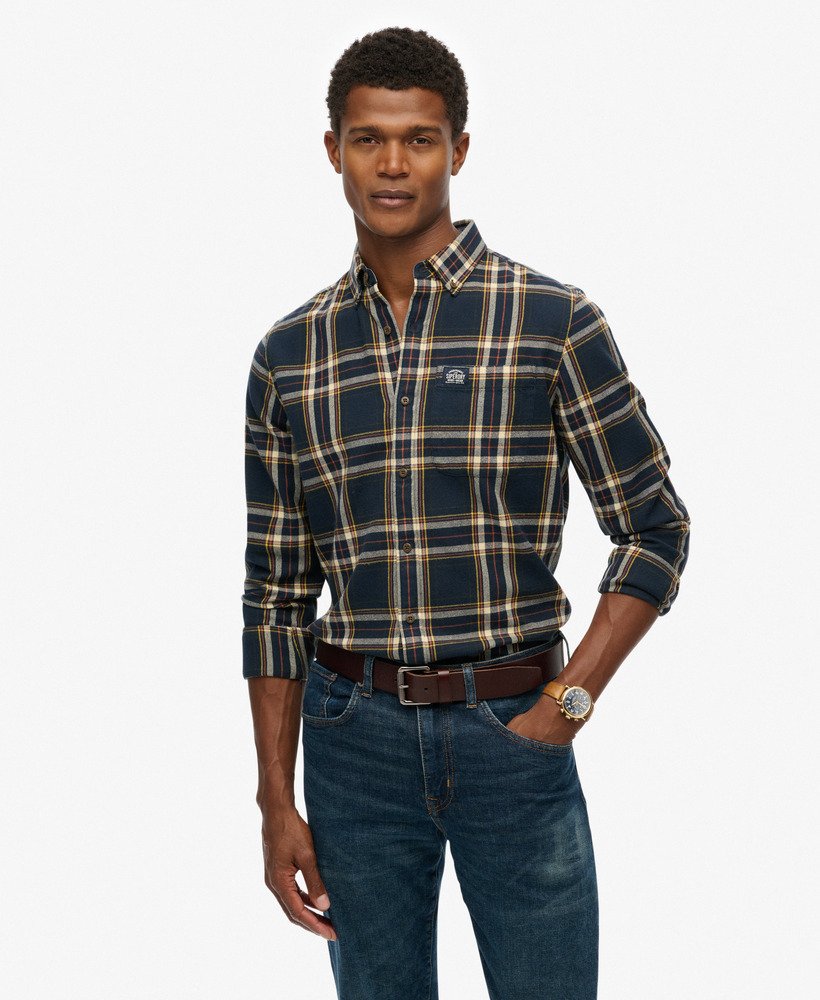 Man wearing a plaid shirt and jeans on a white background