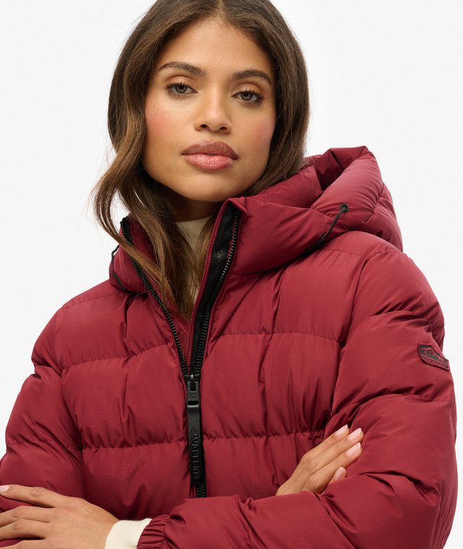 Woman wearing a red puffer jacket on a white background