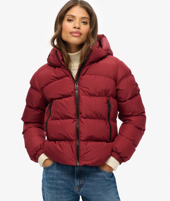 Woman wearing a red puffer jacket on a white background