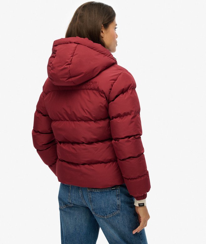 Person wearing a red puffer jacket on a white background