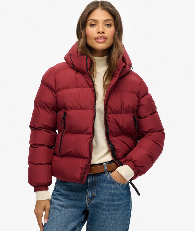 Woman wearing a red puffer jacket on a white background
