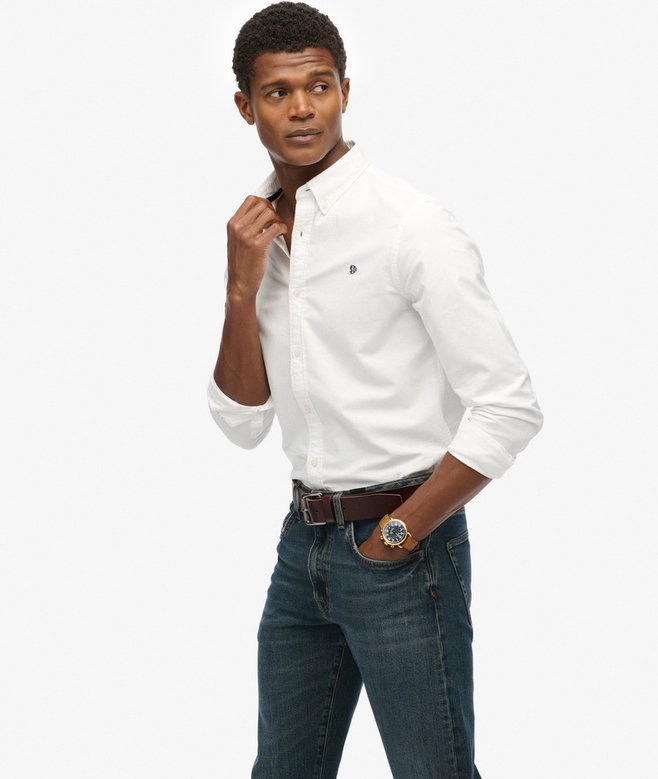 Man wearing a white shirt and blue jeans on a white background