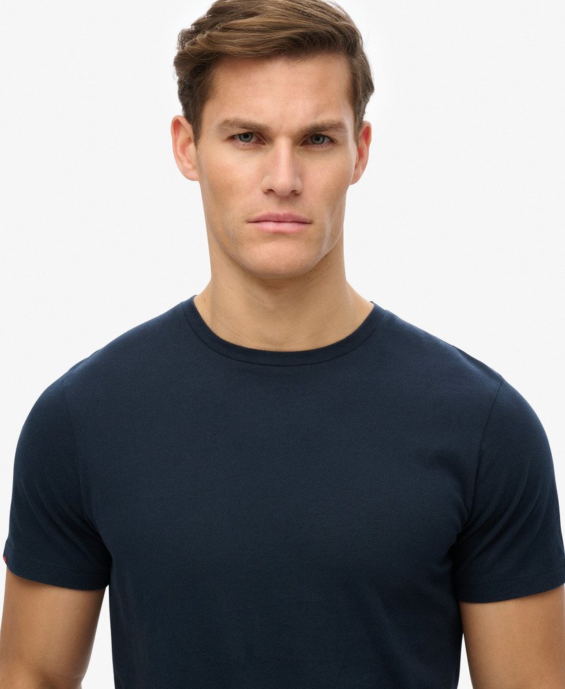 Man wearing a navy blue t-shirt against a plain background