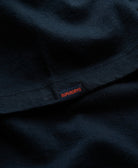 Close-up of a navy blue fabric with Superdry logo tag.