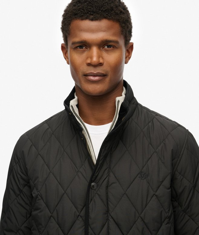 Man wearing a black quilted jacket on a white background