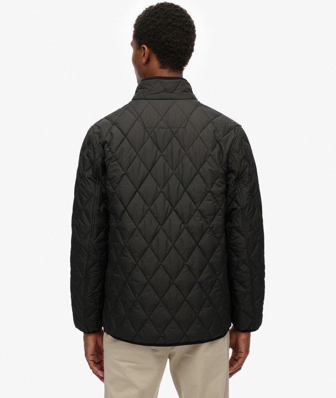 Person wearing a black quilted jacket on a white background
