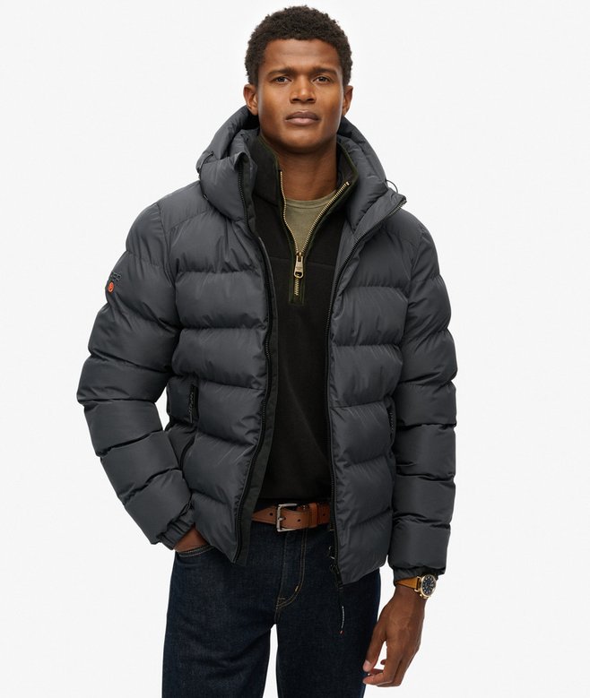 Man wearing a gray puffer jacket on a white background