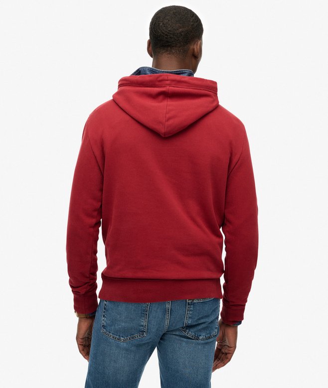Person wearing a red hoodie and blue jeans on a white background