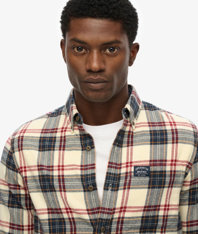 Man wearing a plaid shirt with a visible brand logo on a white background