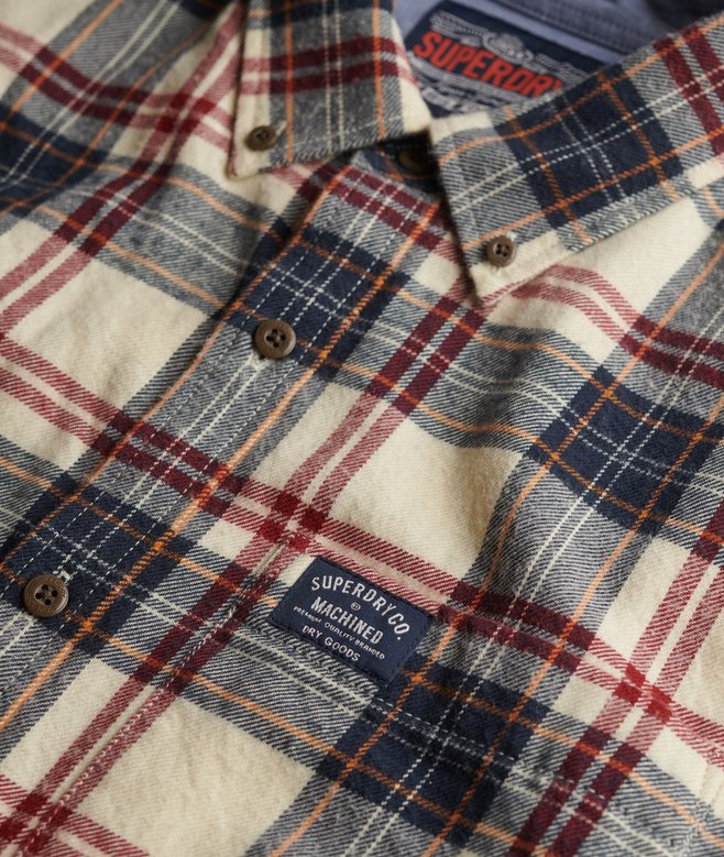 Plaid shirt with 'Superdry' label on a close-up of collar and chest area