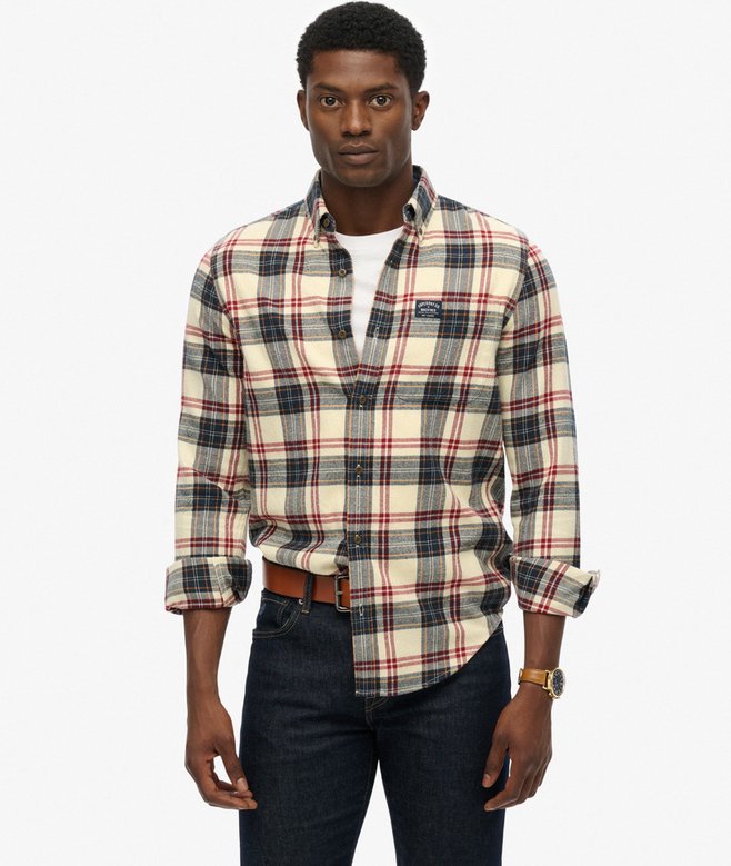Man wearing a plaid shirt with a visible brand logo on a white background