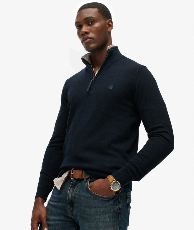 Man wearing a navy blue sweater with a white background