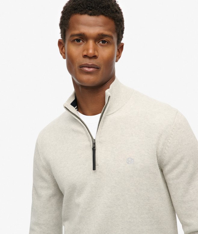 Man wearing a light gray quarter-zip sweater on a white background