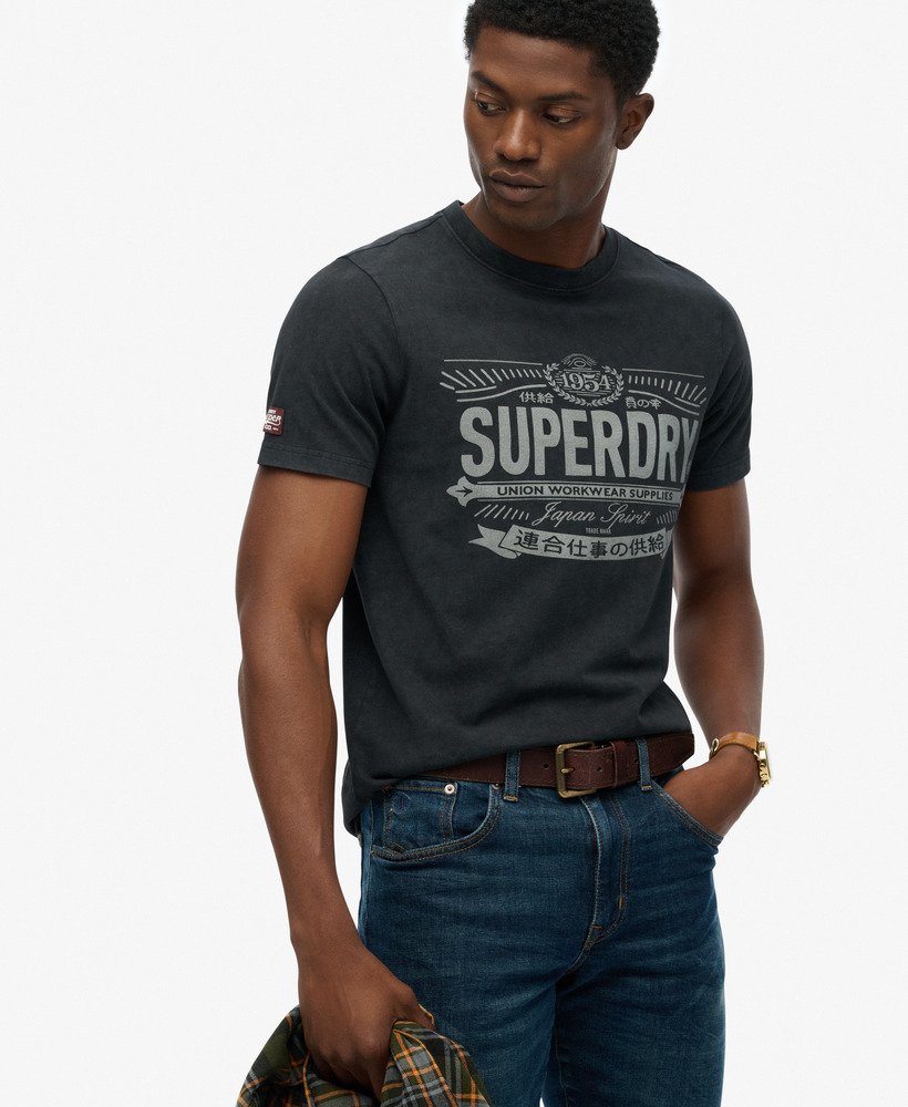 Man wearing a black Superdry t-shirt with text on a white background