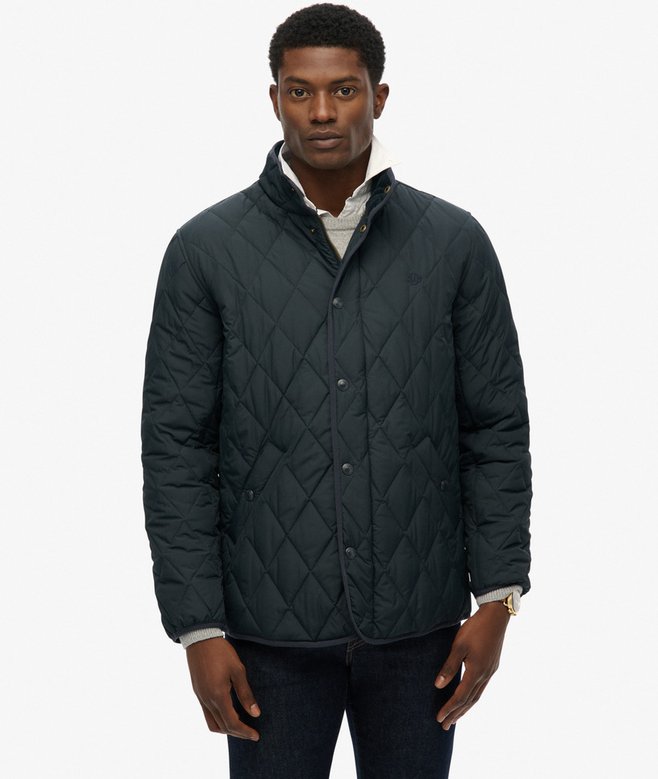 Man wearing a navy quilted jacket on a white background