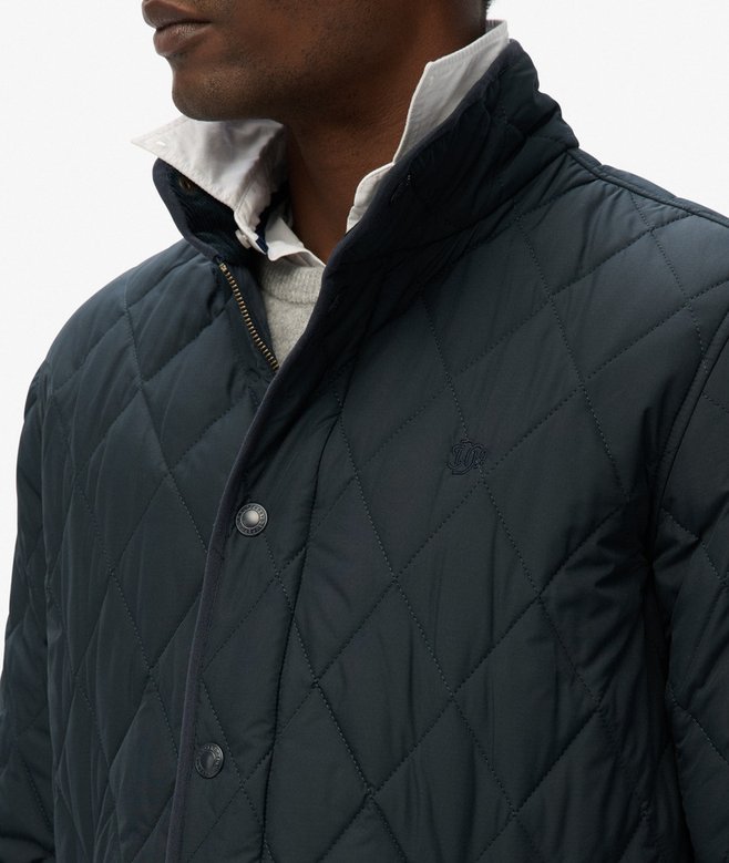Navy quilted jacket worn by a person on a white background