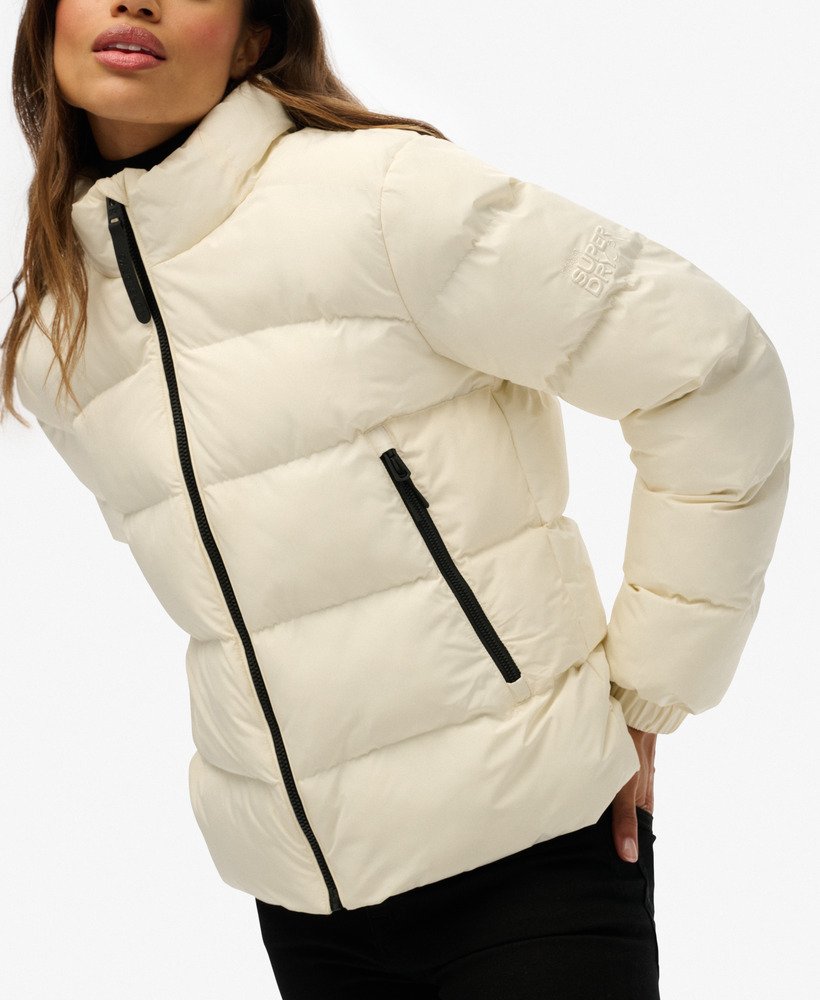 White puffer jacket with black zippers on a white background