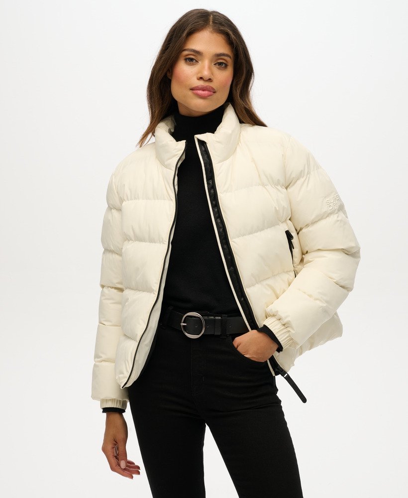 Woman wearing a white puffer jacket on a white background