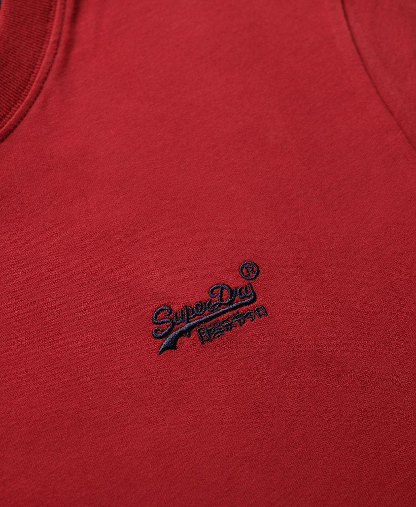 Close-up of a red garment with a navy logo on a red background