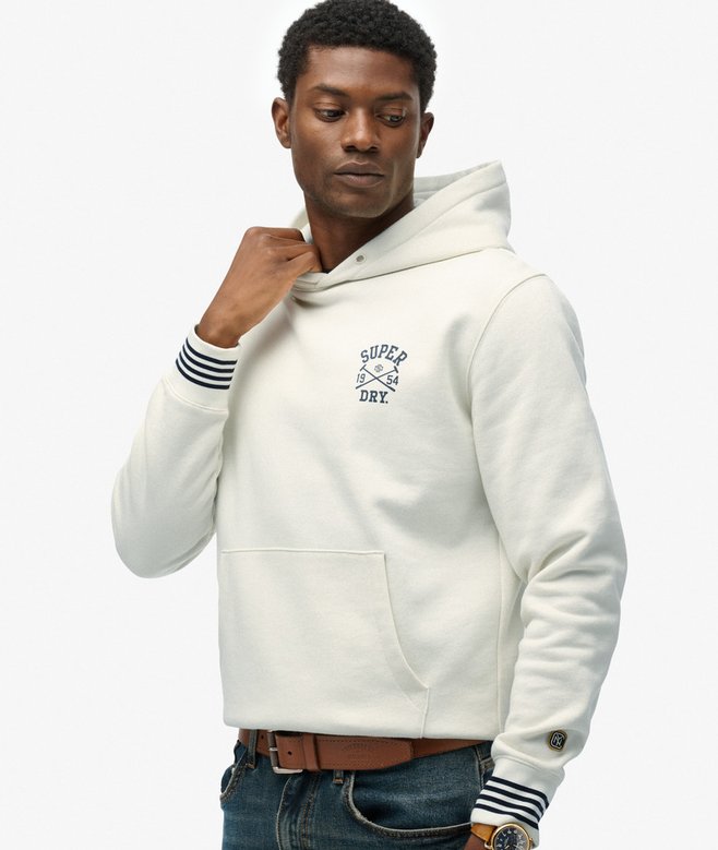 Man wearing a white hoodie with 'Superdry' branding on a white background