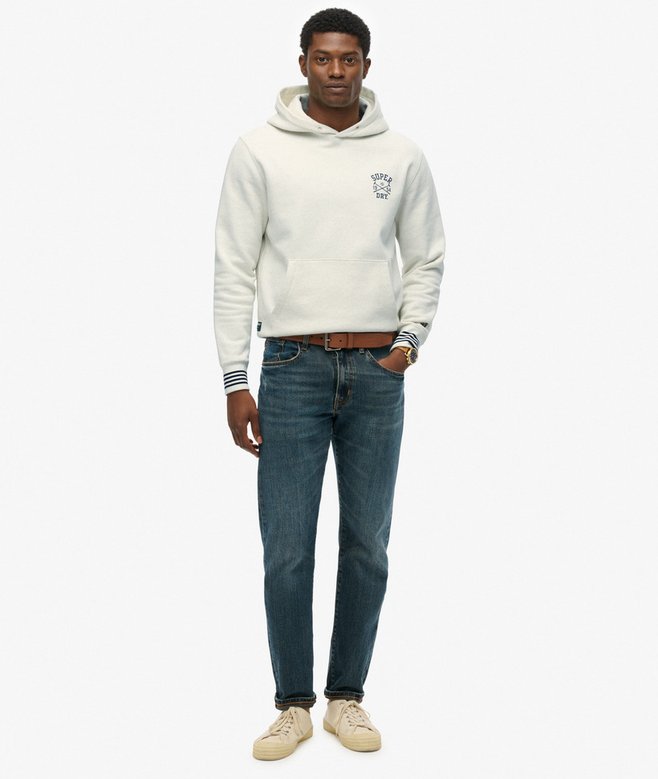 Man wearing a white hoodie and blue jeans on a white background