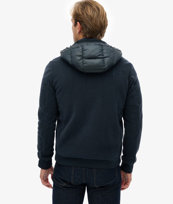 Man wearing a dark blue hoodie with a hood on a white background