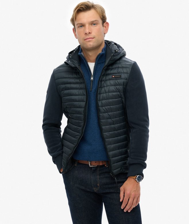 Man wearing a navy quilted jacket on a white background