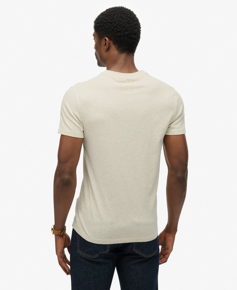 Man wearing a beige t-shirt and dark jeans on a white background-Back view