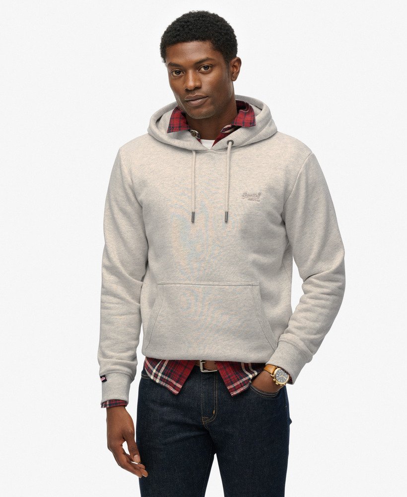Man wearing a light gray hoodie with plaid shirt and jeans on a white background